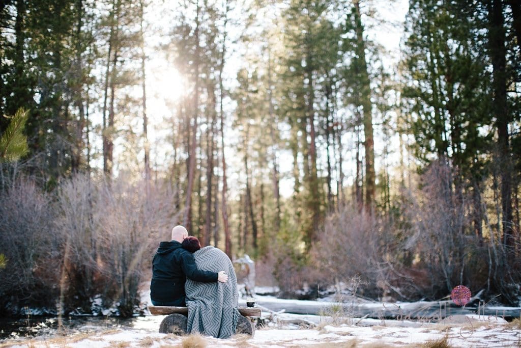 Sitting couple in wrapped in a blanket in Bend Oregon engagement photos
