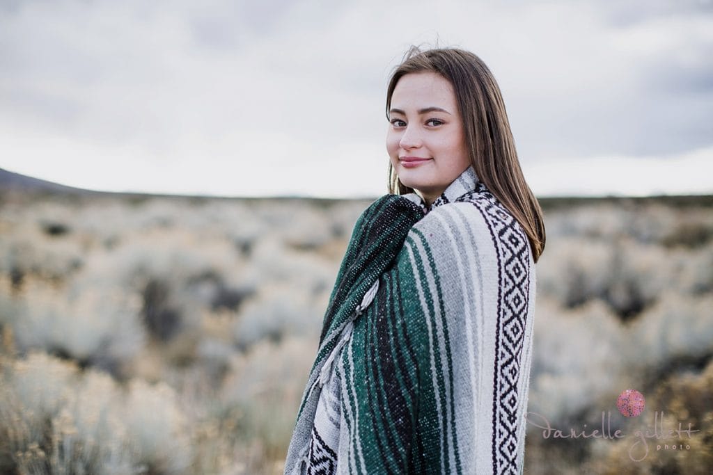 Girl wrapped in blanket for senior pictures in Bend Oregon